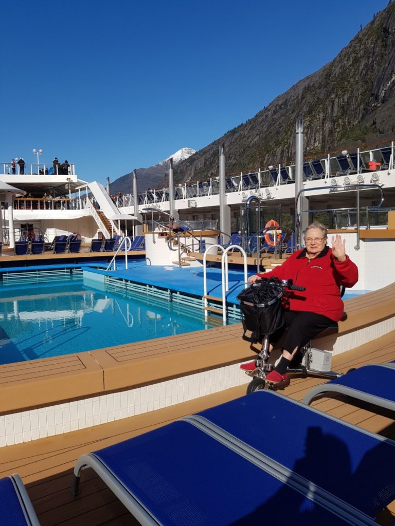 a woman riding a 3 wheel mobility scooter on a cruise ship in Canada